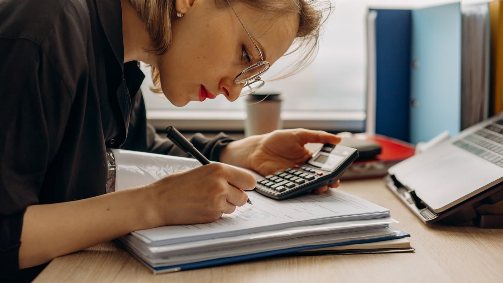 Autónomo revisando cuentas con una calculadora sobre la mesa