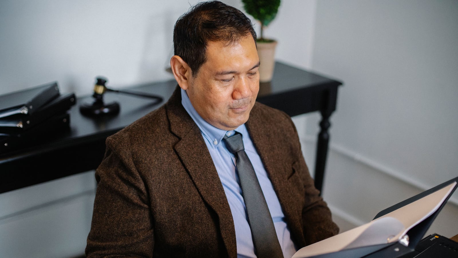 Una persona revisa documentos con cautela en su mesa, valorando riesgos.