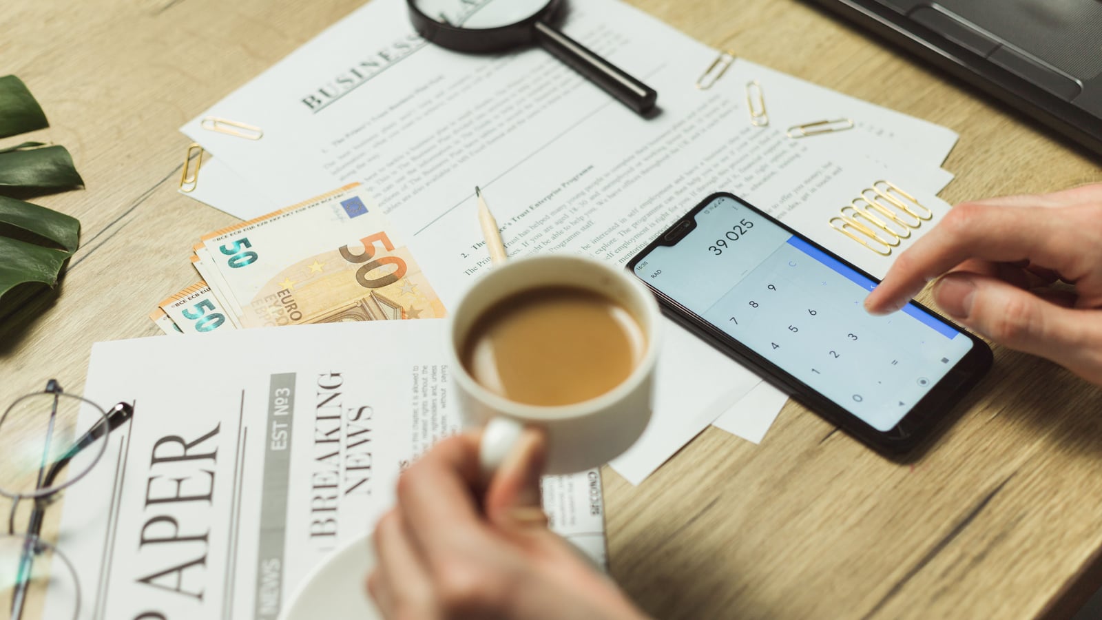 Una persona calcula el ROI con una calculadora y documentos financieros.