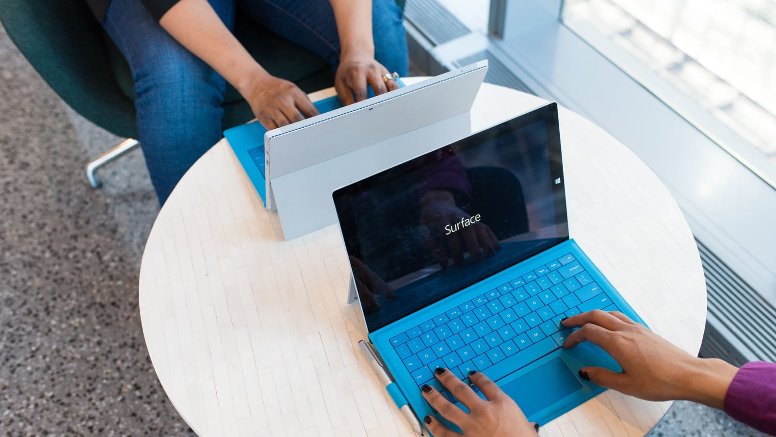 Una persona compara dos opciones de software en pantallas, cara a cara, sobre la mesa.